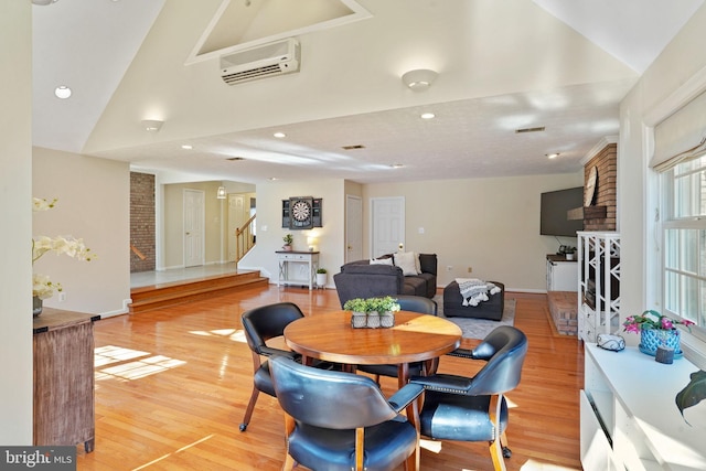 dining space featuring recessed lighting, light wood-style floors, stairs, and a wall unit AC