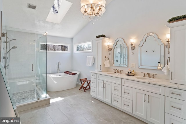 bathroom with visible vents, a soaking tub, vaulted ceiling with skylight, double vanity, and a shower stall