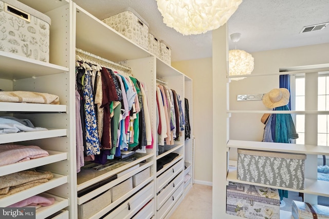 spacious closet featuring a chandelier and visible vents