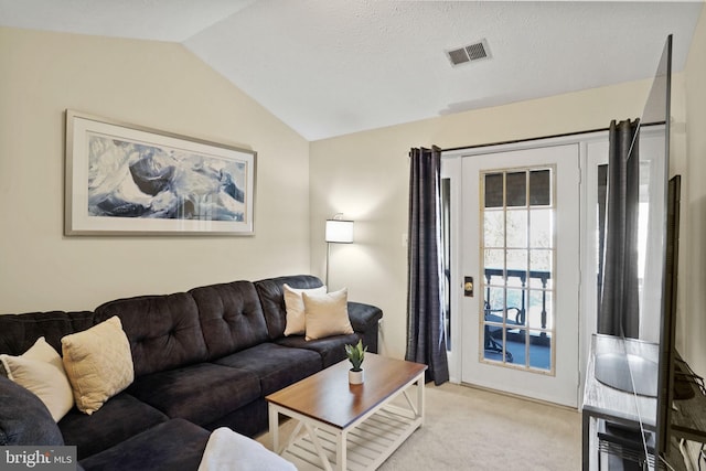 living room with vaulted ceiling, light colored carpet, and visible vents