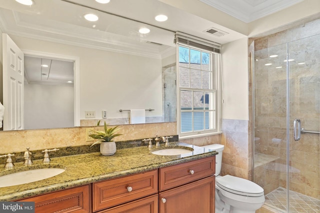 bathroom featuring visible vents, a stall shower, a sink, tile walls, and crown molding