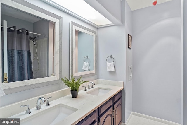 full bathroom with double vanity, baseboards, a shower with curtain, and a sink