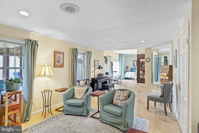 interior space with a textured ceiling and baseboards