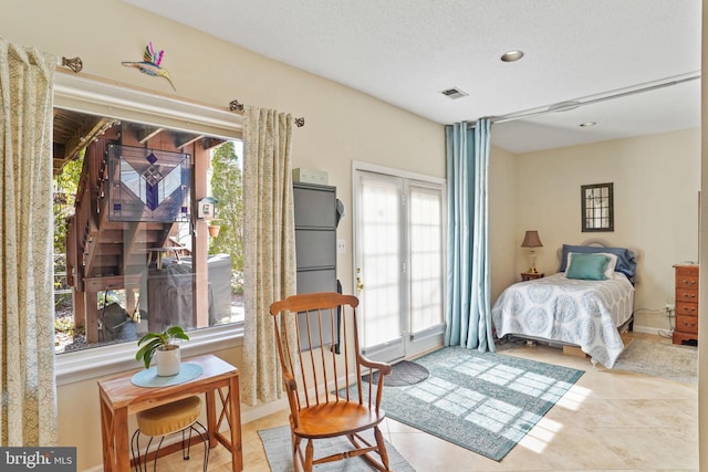 bedroom featuring visible vents, a textured ceiling, and tile patterned flooring