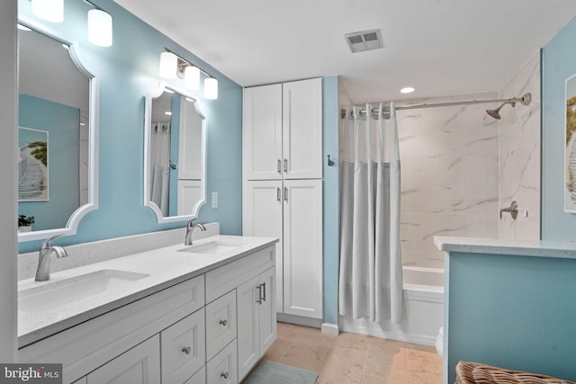 bathroom with double vanity, visible vents, shower / tub combo, and a sink