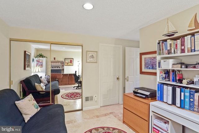 interior space featuring light tile patterned floors, baseboards, visible vents, and a textured ceiling