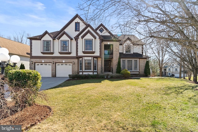 tudor home with a front yard, an attached garage, stucco siding, concrete driveway, and brick siding