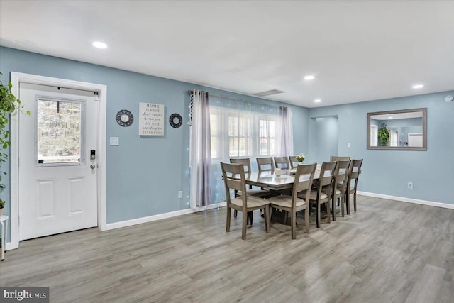 dining space with plenty of natural light, baseboards, and wood finished floors