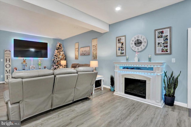 living room with recessed lighting, wood finished floors, baseboards, and a high end fireplace