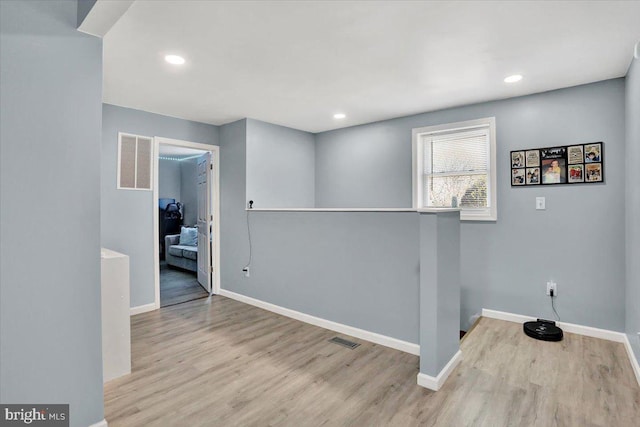 interior space with visible vents, baseboards, and wood finished floors