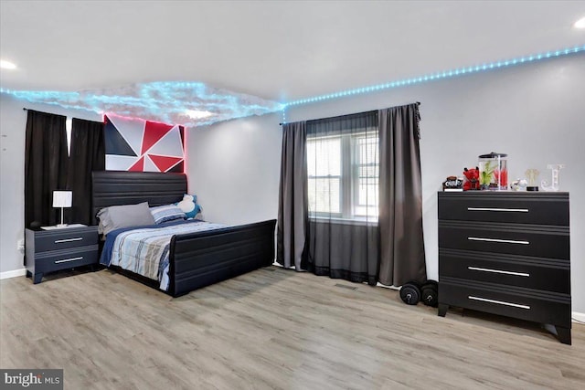 bedroom with light wood finished floors and visible vents