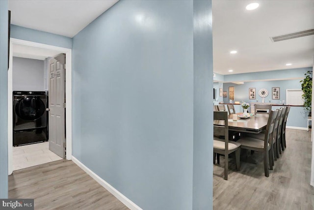 hall with visible vents, baseboards, washer and clothes dryer, recessed lighting, and wood finished floors