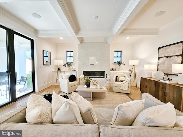 living area with light wood-type flooring, beam ceiling, ornamental molding, and a high end fireplace