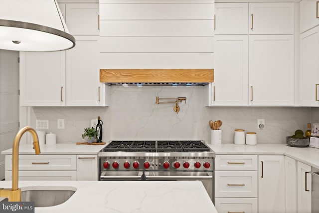 kitchen featuring a sink, white cabinets, and range with two ovens