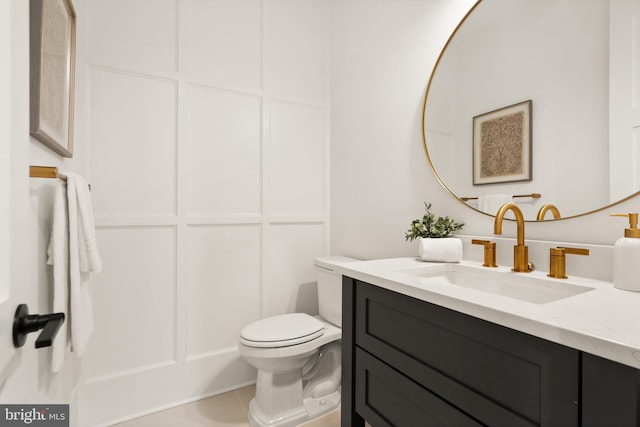 bathroom featuring vanity, tile patterned floors, and toilet