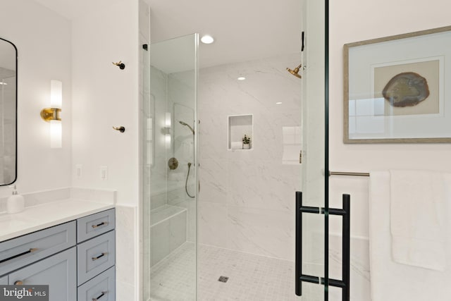 full bath with a marble finish shower and vanity