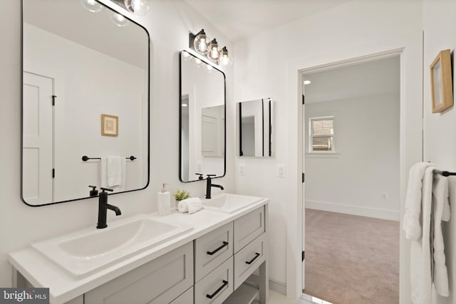 full bathroom with a sink, baseboards, and double vanity