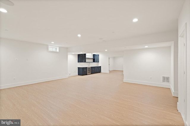 below grade area with recessed lighting, visible vents, baseboards, and light wood-style floors