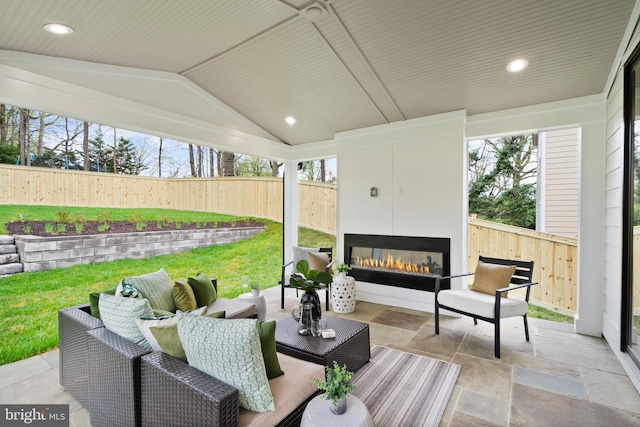 view of patio with a fenced backyard and an outdoor living space with a fireplace