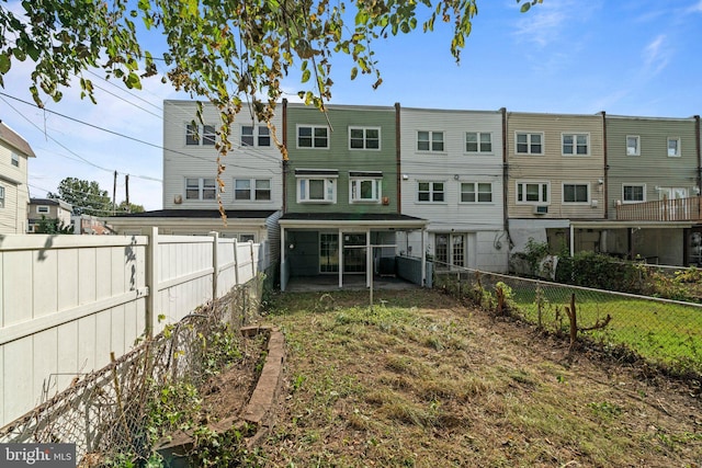 back of property with a yard and a fenced backyard