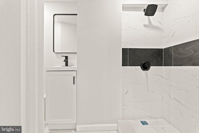 bathroom with marble finish floor, vanity, a shower, and baseboards