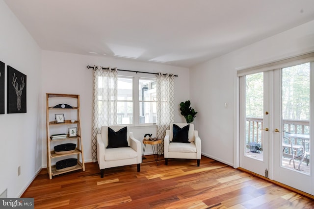 sitting room with baseboards and light wood finished floors