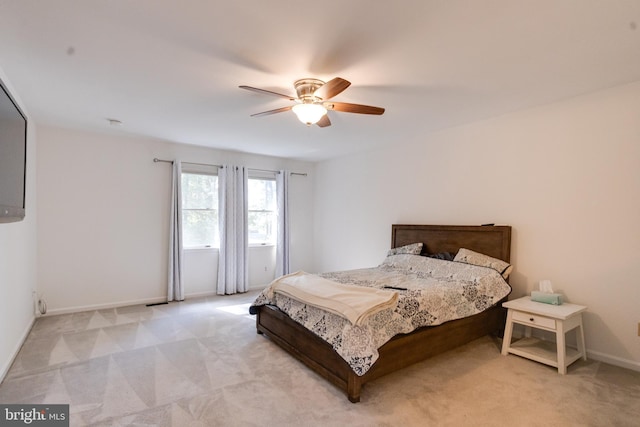 bedroom with light carpet, ceiling fan, and baseboards