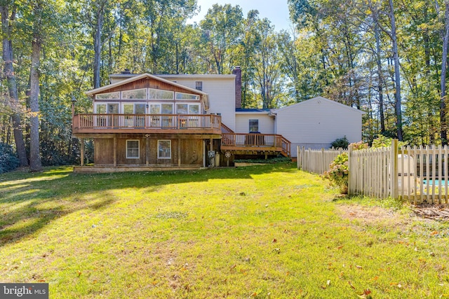 back of property featuring a lawn, a chimney, a deck, and fence