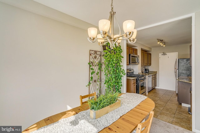 dining space featuring light tile patterned floors and an inviting chandelier