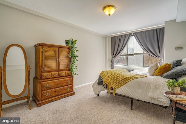 bedroom featuring baseboards and light carpet