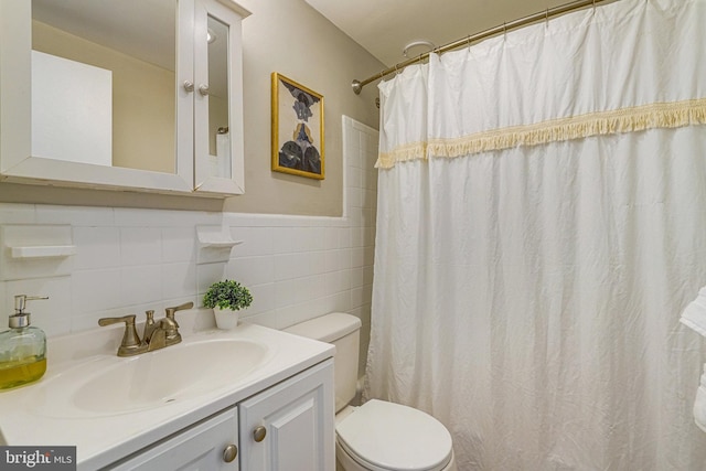 bathroom with vanity, toilet, tile walls, and a shower with curtain