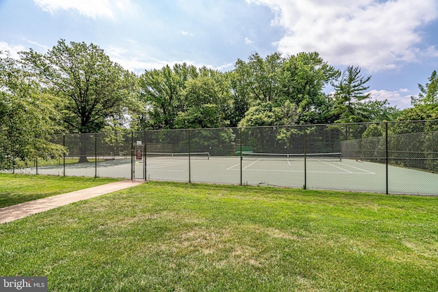 view of sport court featuring a yard and fence