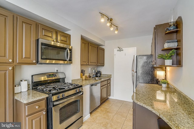 kitchen featuring light tile patterned floors, light stone countertops, open shelves, a sink, and appliances with stainless steel finishes