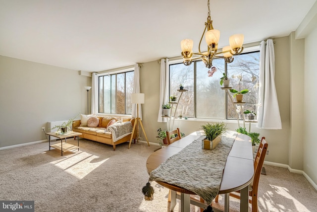 carpeted dining space with baseboards and a chandelier