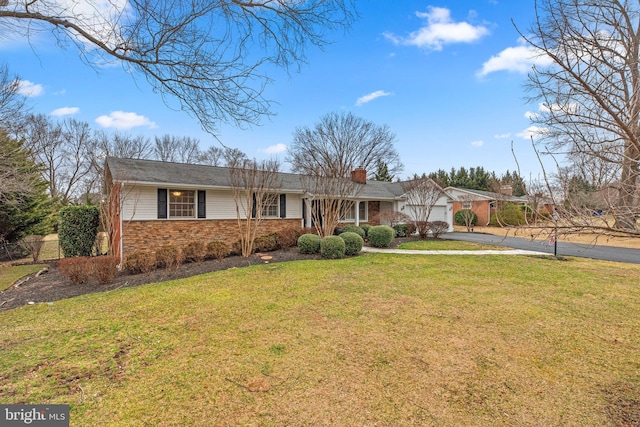 single story home with a front lawn, aphalt driveway, an attached garage, brick siding, and a chimney