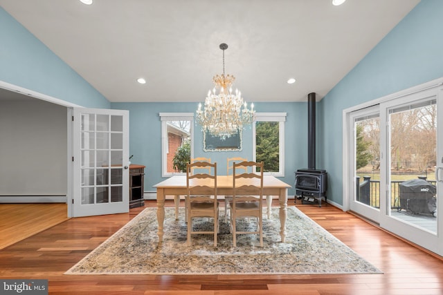 dining space featuring recessed lighting, a baseboard heating unit, lofted ceiling, and wood finished floors