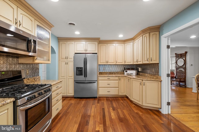 kitchen with cream cabinetry, visible vents, and appliances with stainless steel finishes