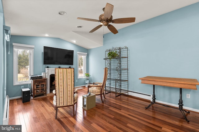 sitting room with baseboards, vaulted ceiling, and hardwood / wood-style flooring