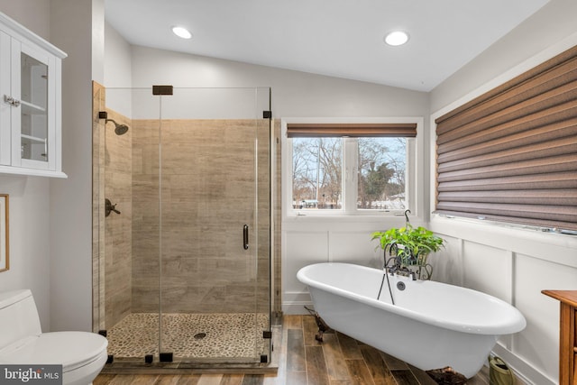 bathroom with lofted ceiling, a soaking tub, wood finished floors, and a shower stall