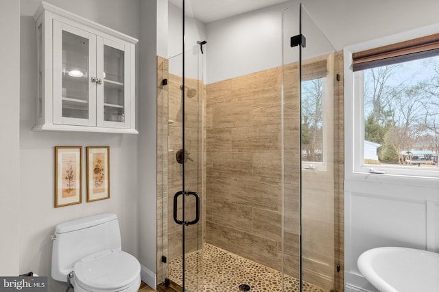 full bathroom featuring a freestanding tub, toilet, and a stall shower