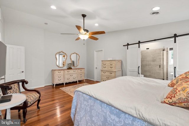 bedroom featuring visible vents, recessed lighting, a barn door, and wood finished floors