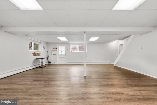 basement featuring baseboard heating and wood finished floors