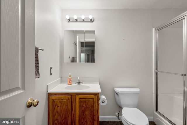 bathroom featuring vanity, a shower stall, and toilet