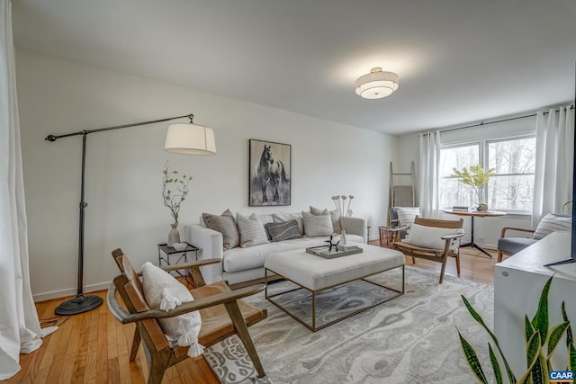 living area featuring light wood-style floors and baseboards