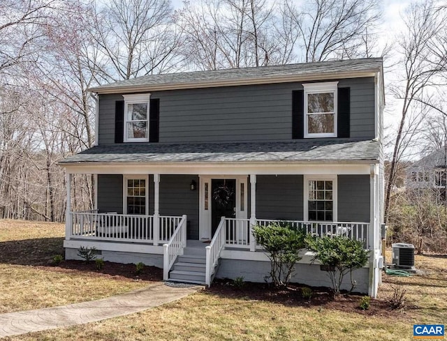 view of front of house with roof with shingles, covered porch, central AC, and a front yard