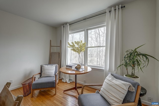 living area featuring light wood-type flooring and baseboards