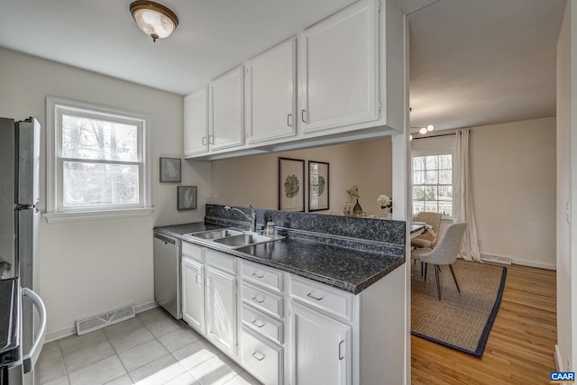 kitchen featuring visible vents, a sink, white cabinetry, appliances with stainless steel finishes, and a peninsula