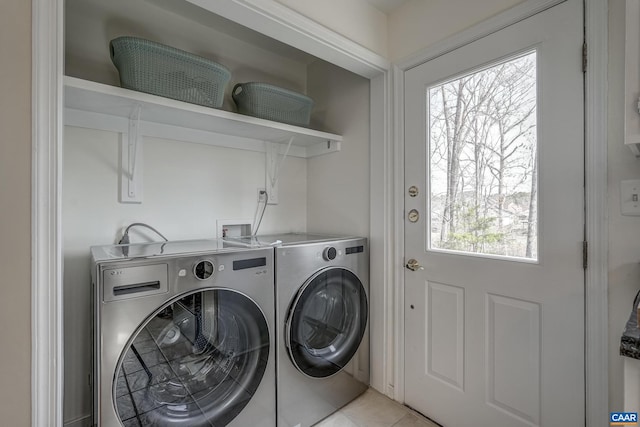 laundry area featuring washer and dryer, laundry area, and light tile patterned flooring