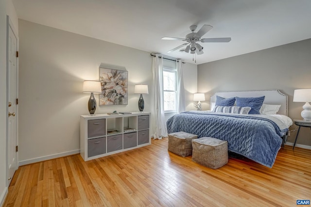 bedroom featuring a ceiling fan, baseboards, and light wood finished floors