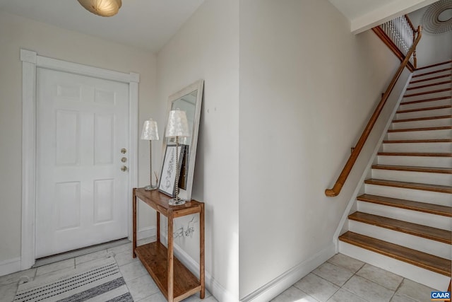 entrance foyer with baseboards, light tile patterned flooring, and stairs